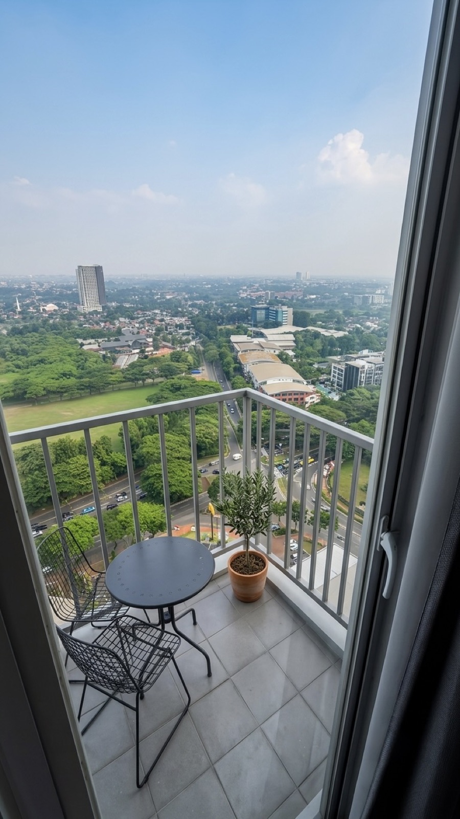 Balcony with bistro table overlooking BSD City greenery and roads below